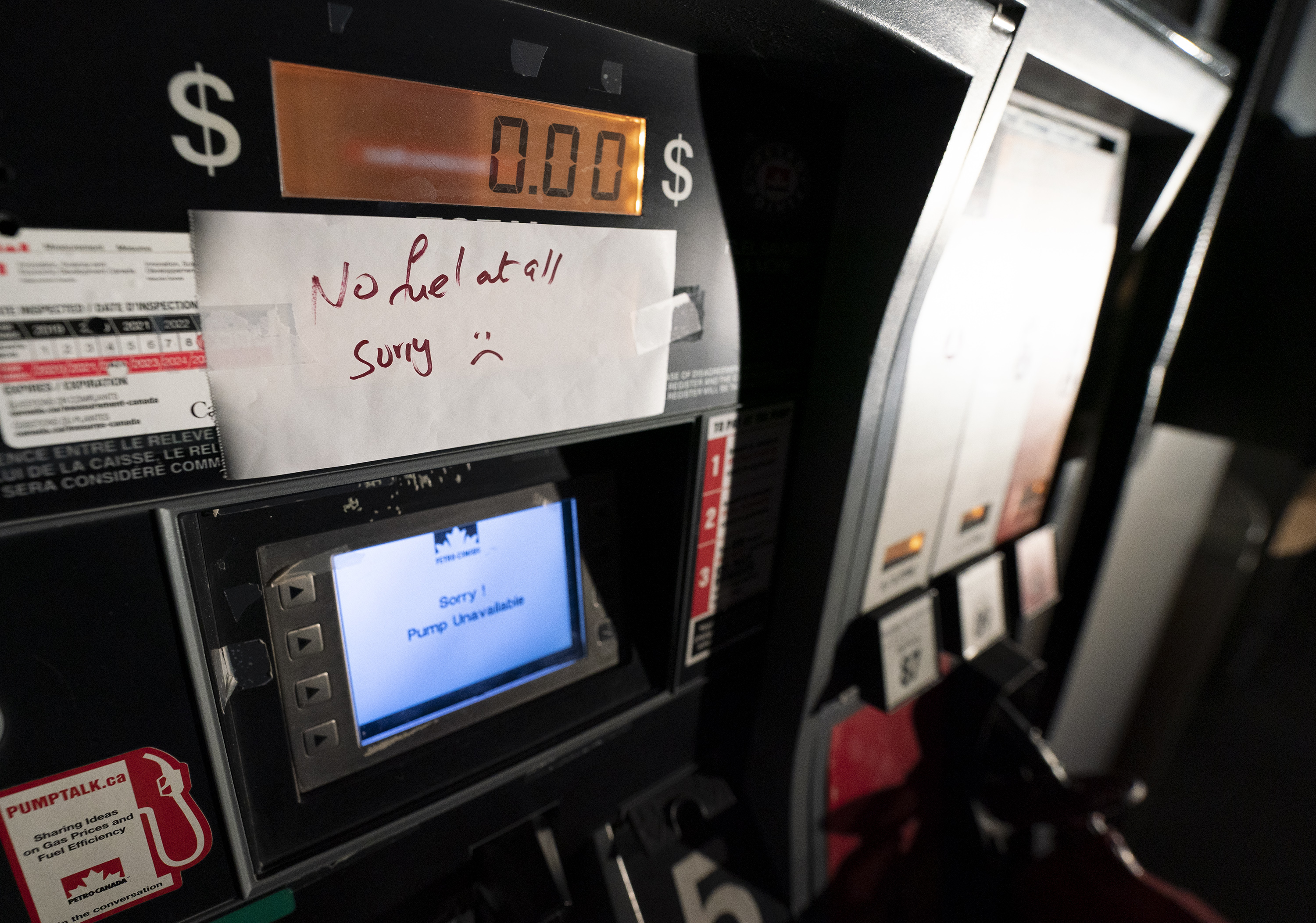 A gas pump with a sign noting no fuel available in British Columbia