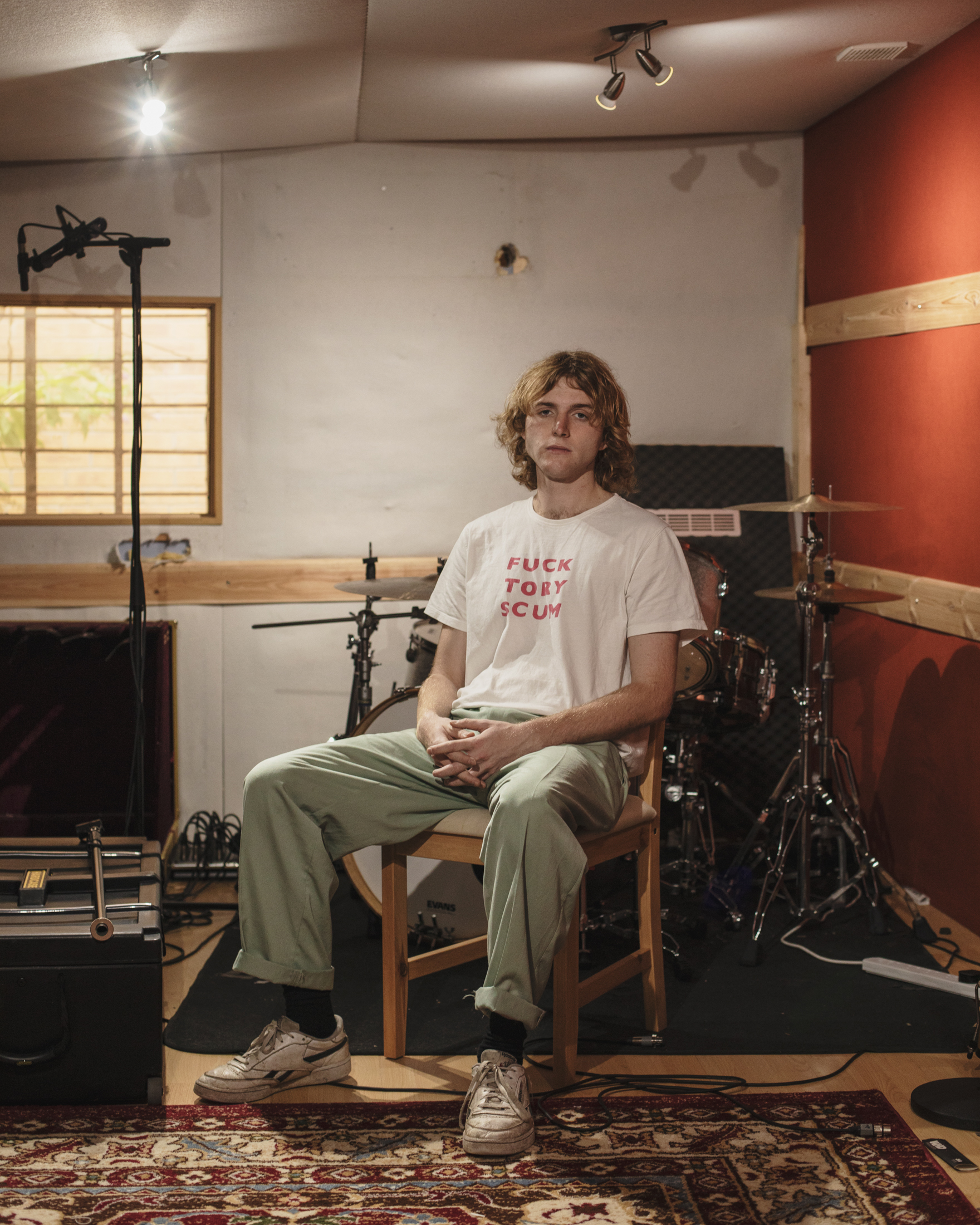 Long covid patient Charlie Forbes sitting in front of a drum kit