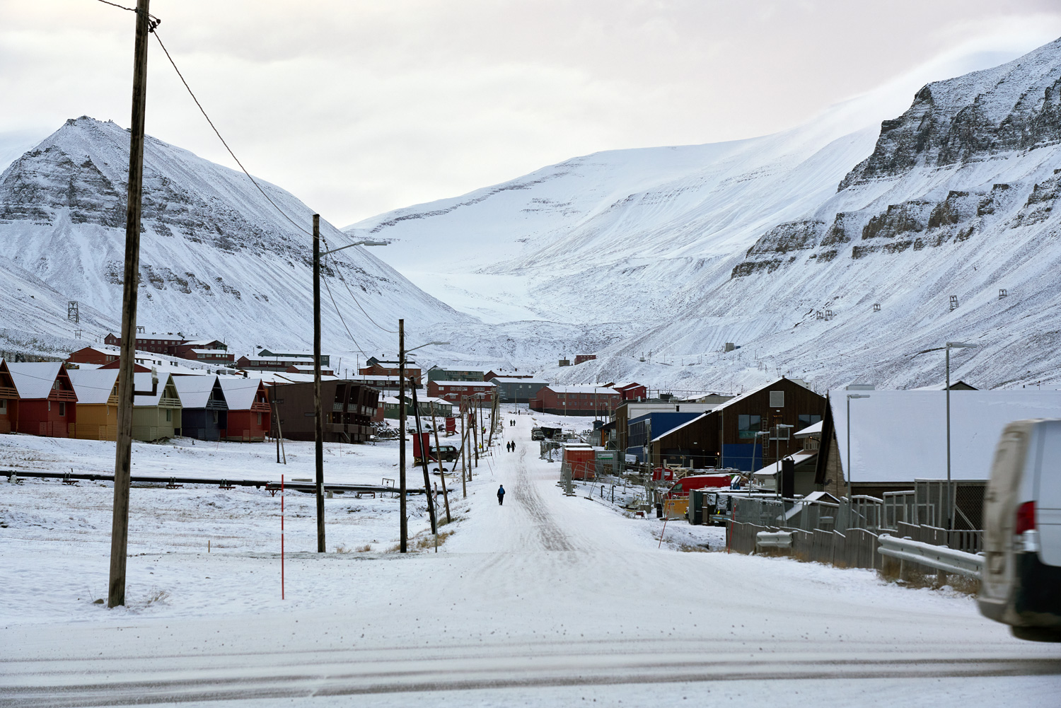 Arctic cuisine, Svalbard, Nick Casini - Photograph of snow lined street in between two snow-covered mountains.