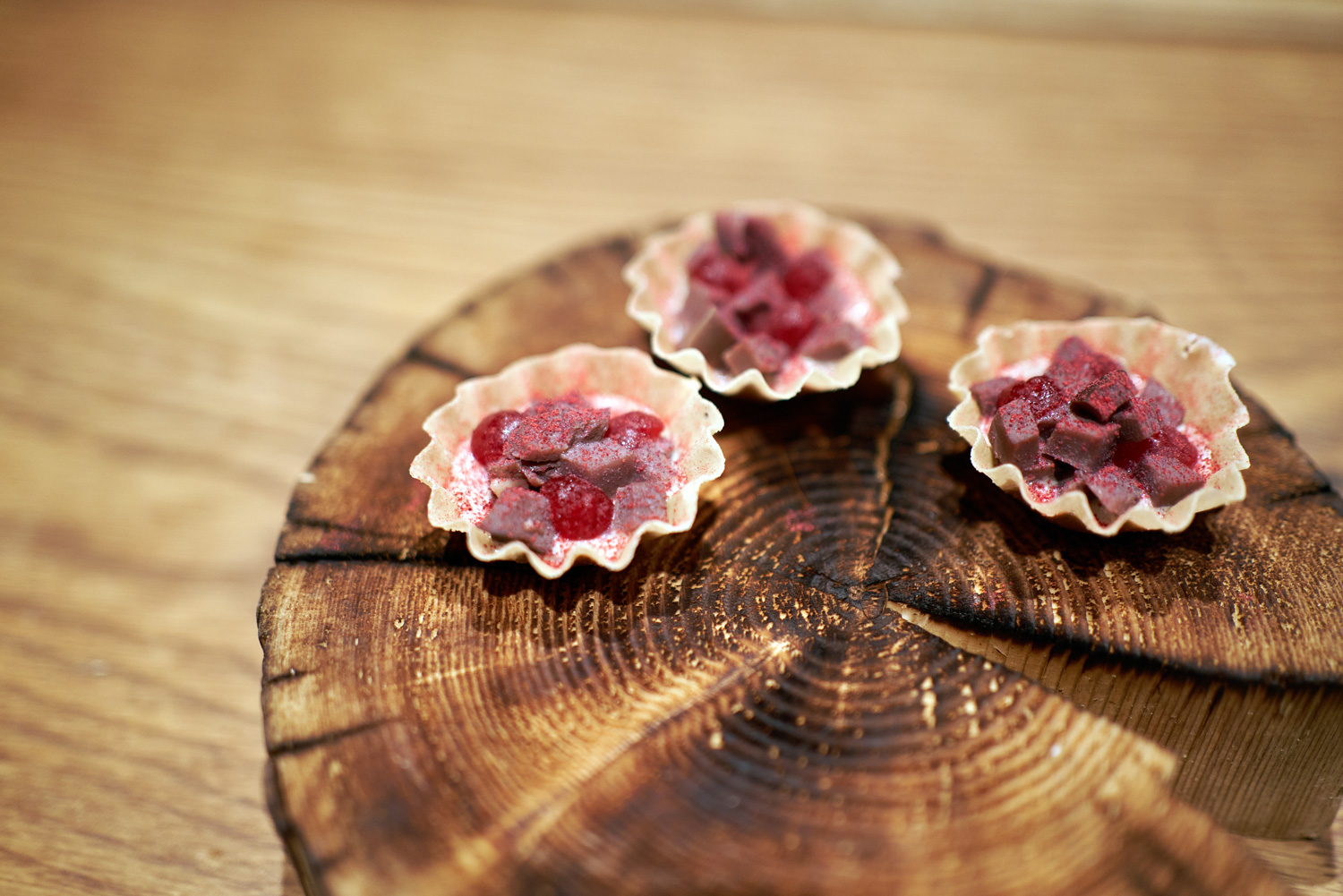 Arctic cuisine, Svalbard, Nick Casini - Photo of red meat served in a shell, on top of a log.