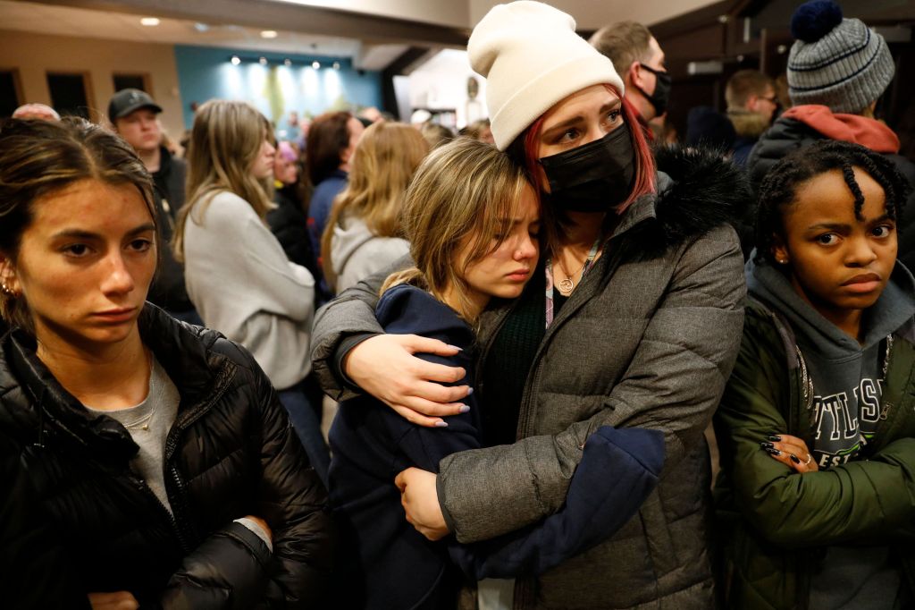 People hug during a vigil after a shooting at Oxford High School at Lake Pointe Community Church in Lake Orion, Michigan on November 30, 2021. (Photo by JEFF KOWALSKY/AFP via Getty Images)