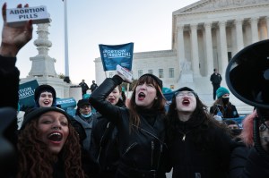 Demonstrators celebrate after taking abortion pills ​outside the Supreme Court on December 1, 2021. Inside the court, the justices heard arguments in Dobbs v. Jackson Women's Health, a case about a Mississippi law that bans most abortions after 15 weeks.