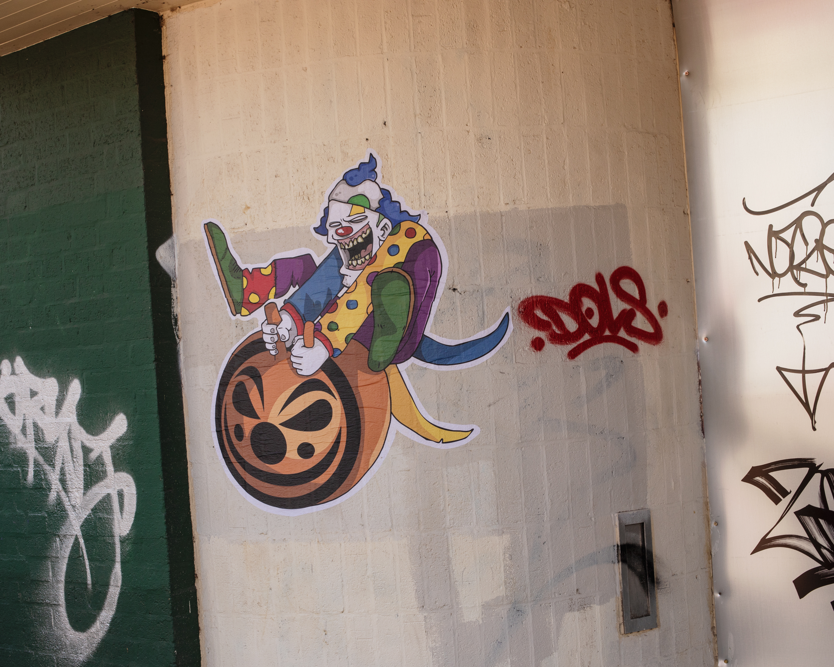 A sticker of a clown on a grafitti-ed wall in Birmingham