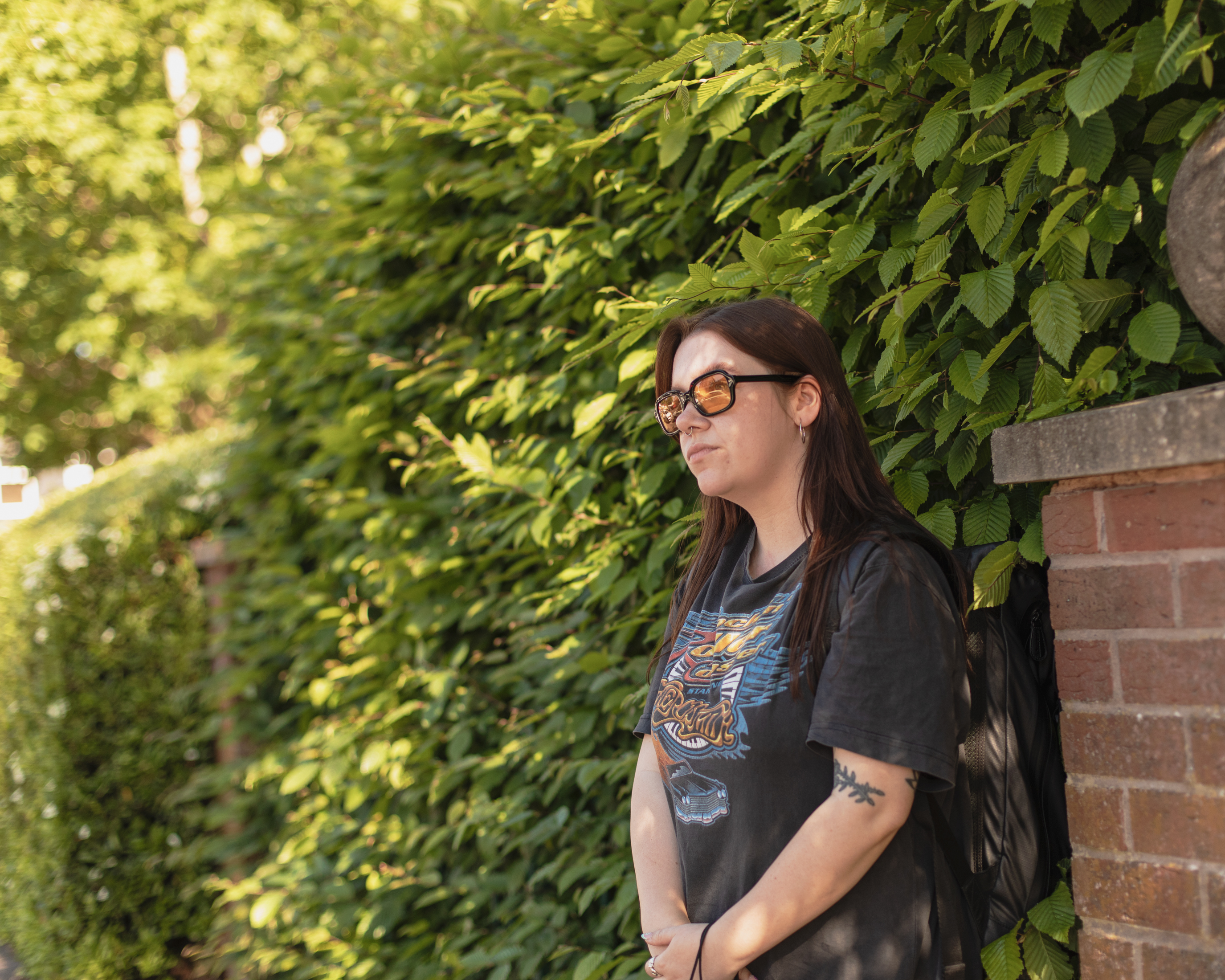 VICE writer Lauren O'Neill in Birmingham leaning against a hedge