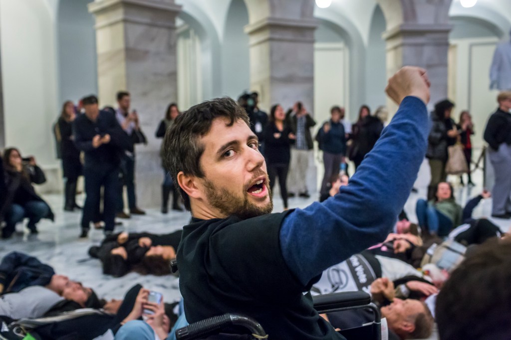 Activist Ady Barkan protesting in the Capitol.