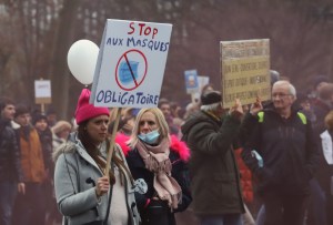 A demonstrator holds a sign with an anti-mask mandate slogan during a protest against Covid-19 restrictions in Brussels, Belgium, on Dec. 19.