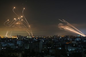 The Israeli Iron Dome missile defence system (L) intercepts rockets (R) fired by the Hamas movement towards southern Israel from Beit Lahia in the northern Gaza Strip as seen in the sky above the Gaza Strip overnight on May 14, 2021. Photo: ANAS BABA/AFP