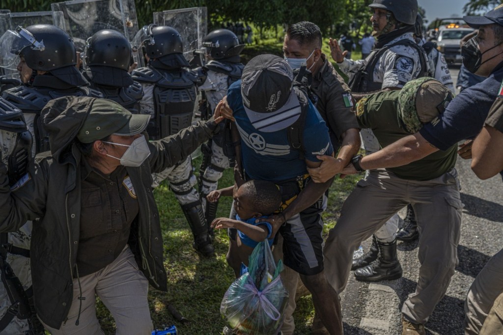 Mexican immigration agents detain a Haitian migrant with his son in Chiapas state, Mexico, on Thursday, Sept. 2, 2021