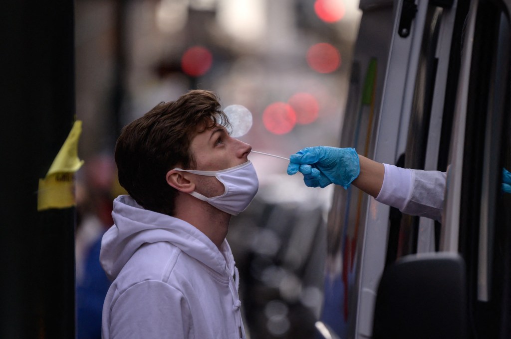 A man receives a nasal swab during a test for Covid-19 at a street-side testing booth in New York on December 17, 2021.