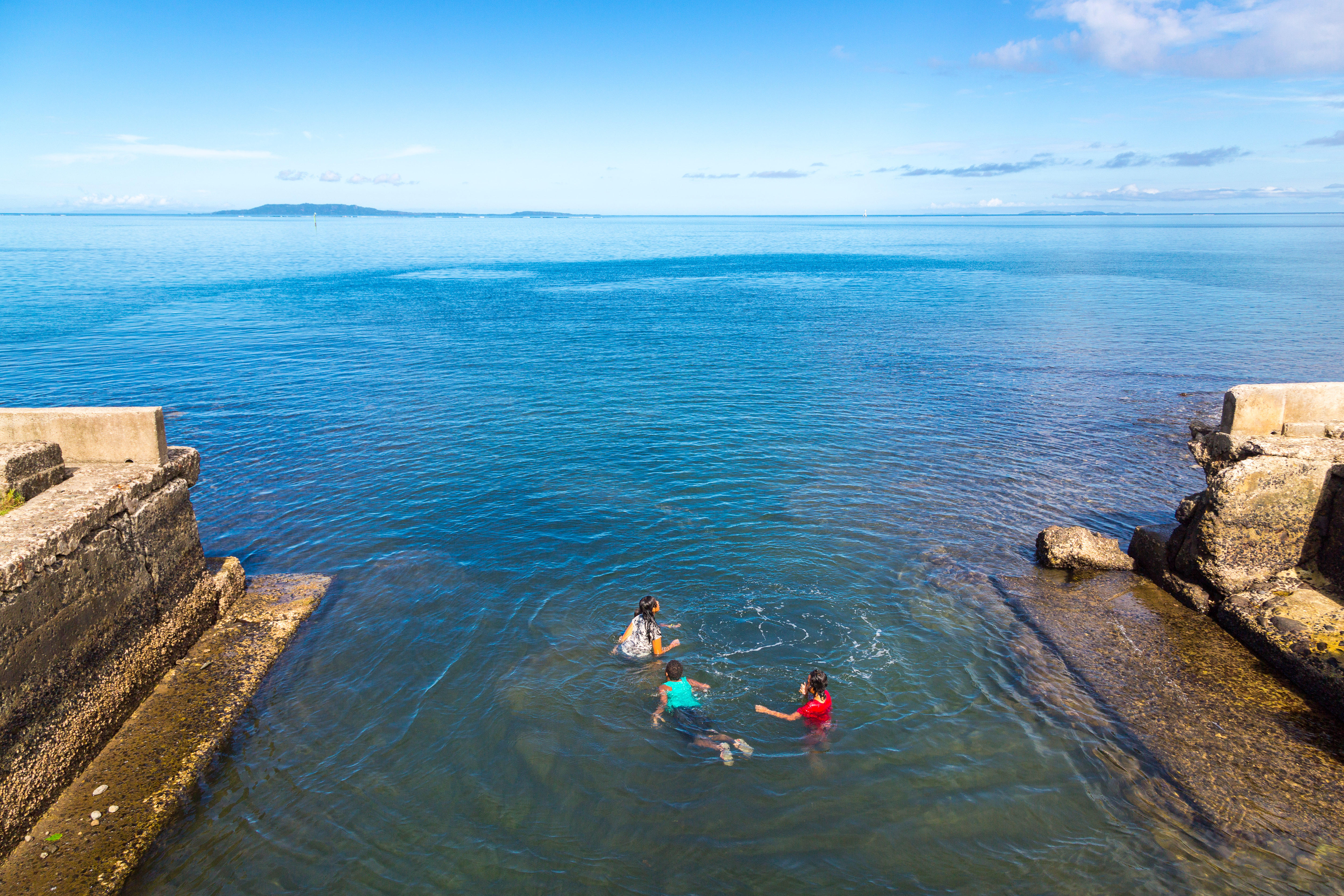 Children swimming off an embankment in Ovalau, Fiji