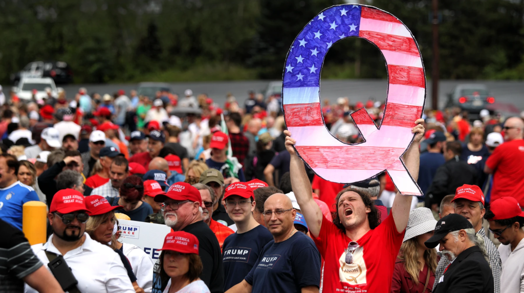 Lelaki mengangkat spanduk besar bertuliskan “Q” dalam Trump Rally yang diadakan di Pennsylvania, Amerika Serikat, pada 2 Agustus 2018. (Foto oleh Rick Loomis / Getty Images)