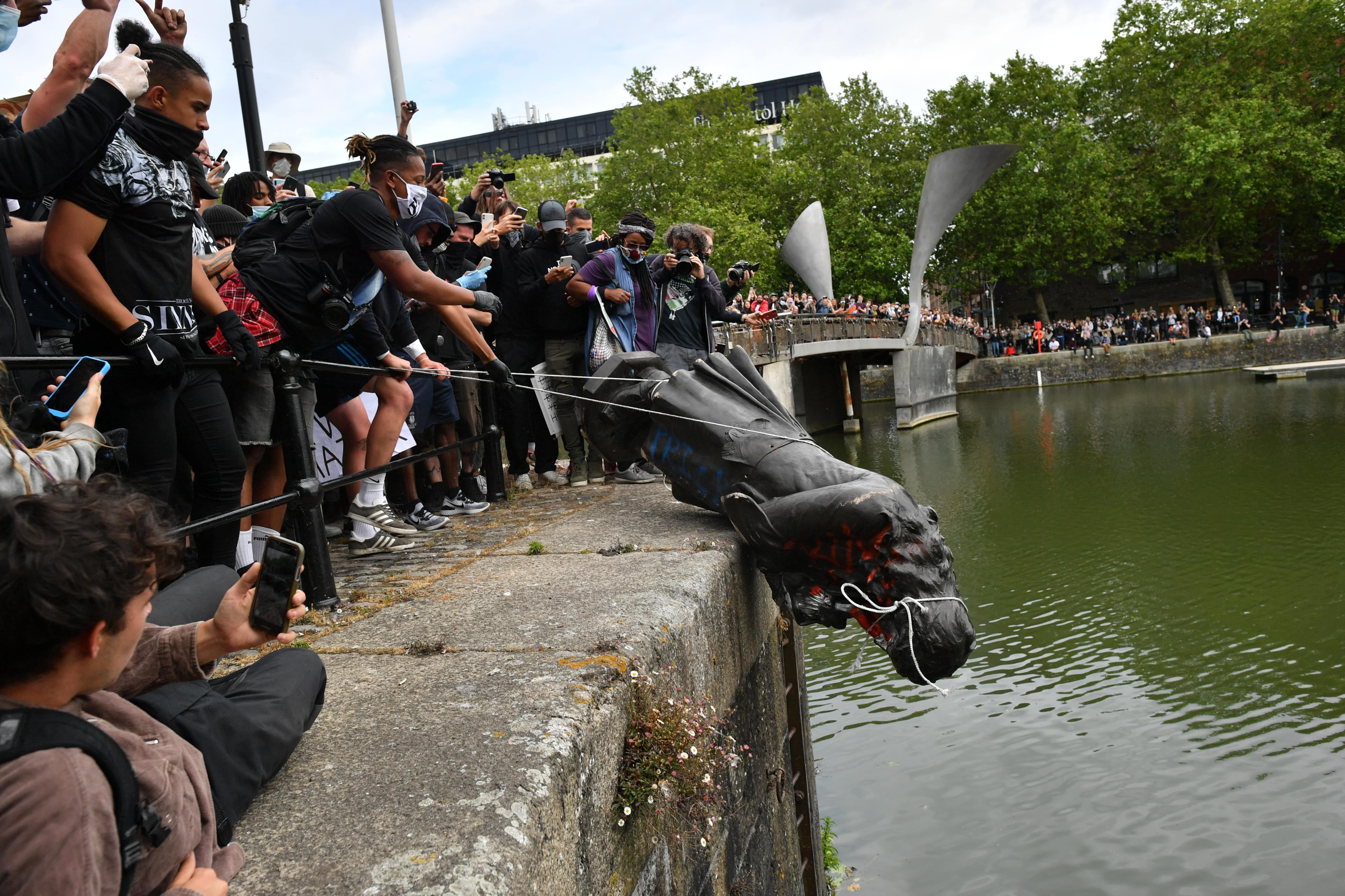 Activists dumping the statue of Colston in Bristol harbour. Photo: Ben Birchall/PA