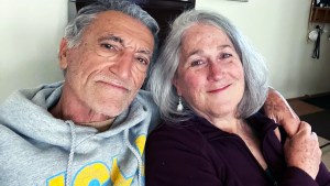 Marriage, couples, romance - Photograph of grey haired man in a hoodie with his arm around a smiling, grey haired woman.