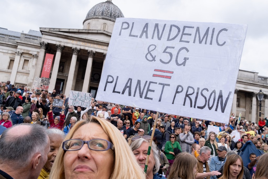 Protestor holding anti-5G sign at anti-lockdown protests in Trafalgar Square on 29th August 2020, in London, England.