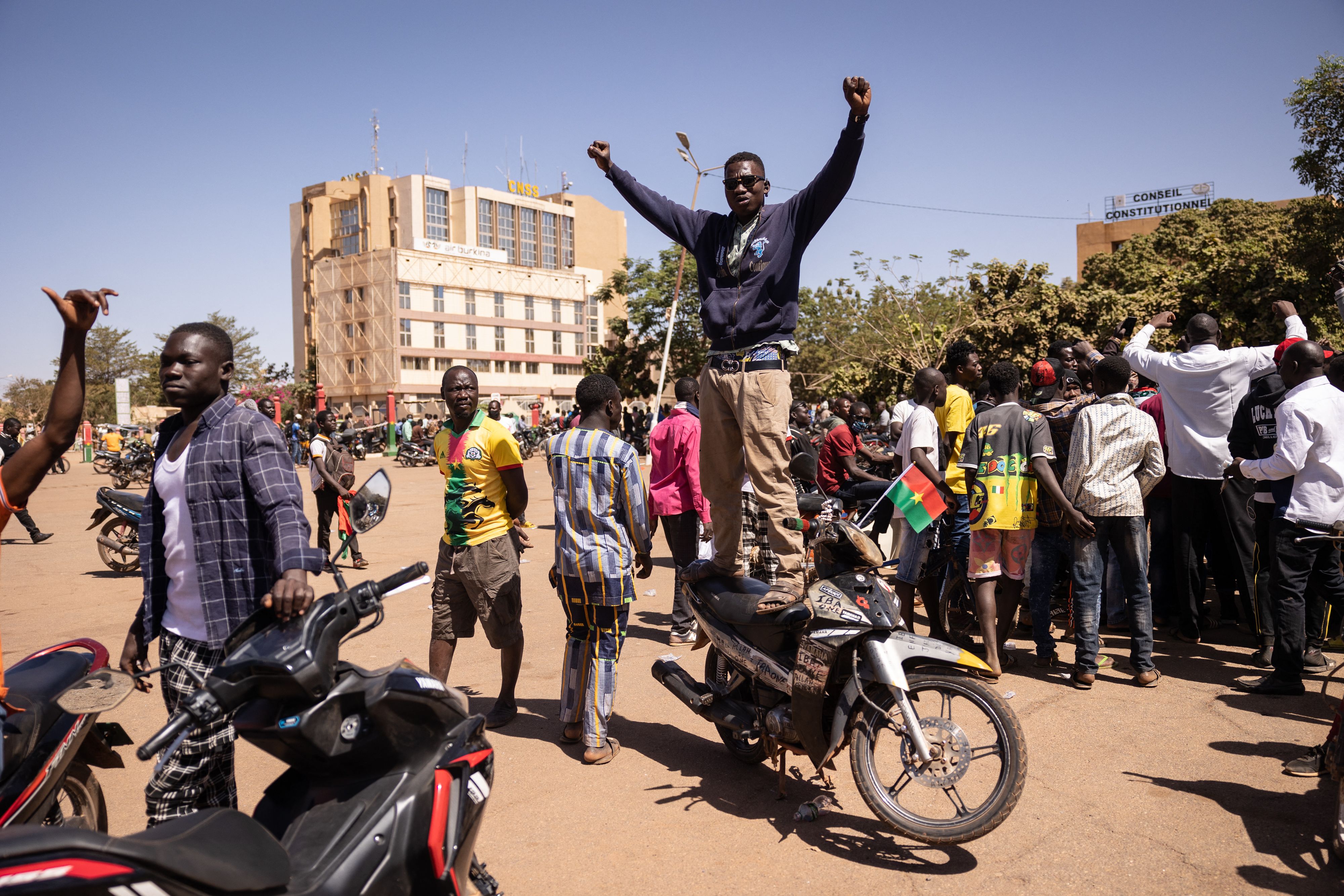 A man standing on his motorcycle gestures as people gather at Nation square to support military in Ouagadougou on January 24, 2022.