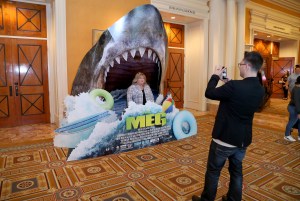 Perempuan berpose di depan papan iklan film “The Meg” di Caesars Palace, Las Vegas, pada 23 April 2018. Foto: Gabe Ginsberg/Getty Images