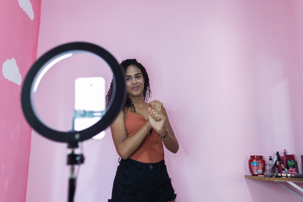 Someone doing a TikTok dance in front of a ring light.