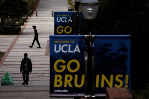 two people walk down a set of stairs on UCLA campus, where classes were canceled after a man issued violent threats against students and faculty.