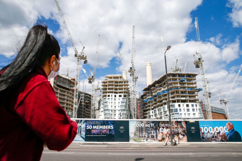 Pejalan kaki melewati lokasi pembangunan Battersea Power di Nine Elms District, London, Inggris. Foto: Hollie Adams/Bloomberg via Getty Images