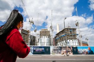 Pejalan kaki melewati lokasi pembangunan Battersea Power di Nine Elms District, London, Inggris. Foto: Hollie Adams/Bloomberg via Getty Images