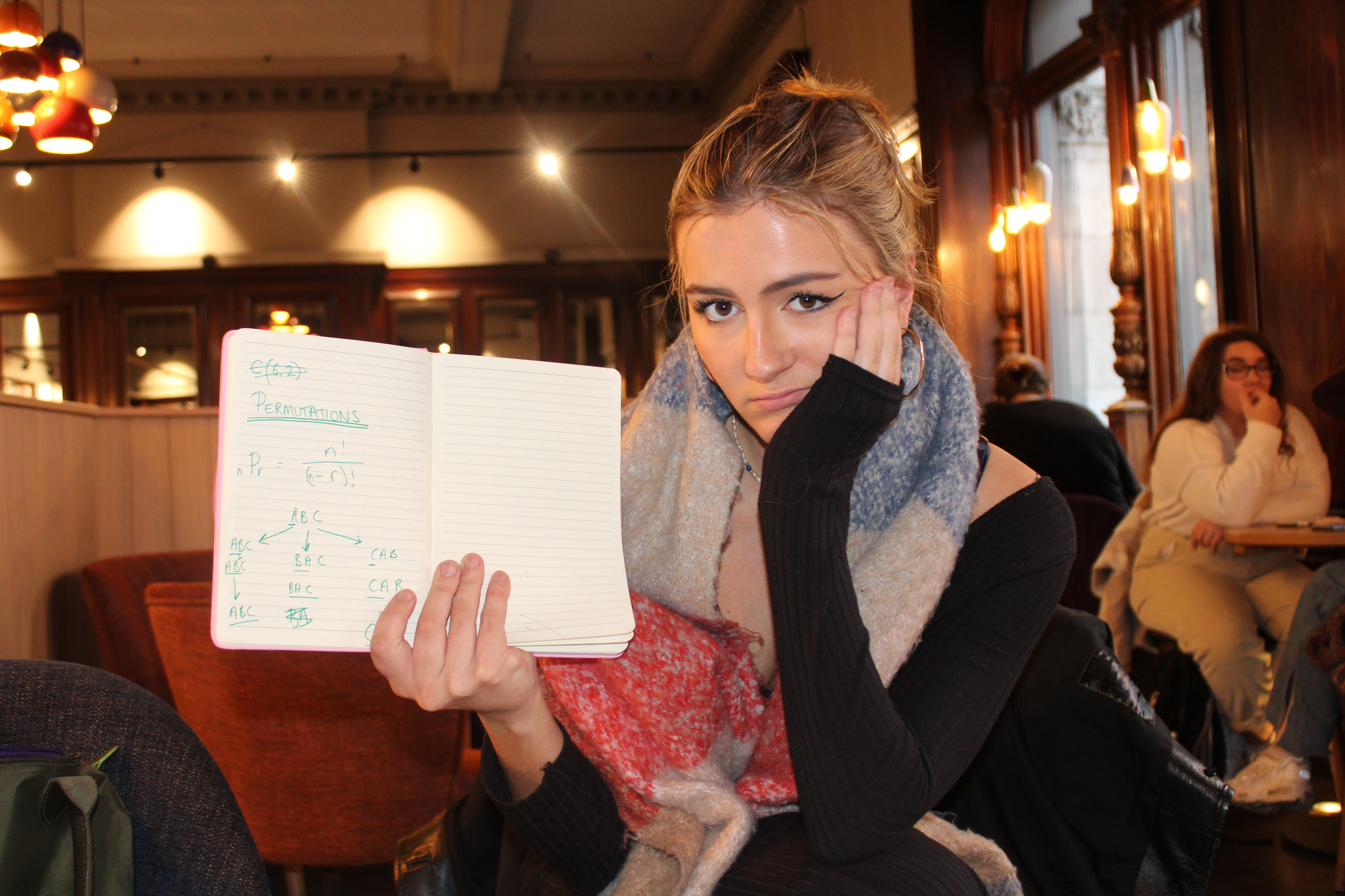 The author holding up a notebook working out permutations.