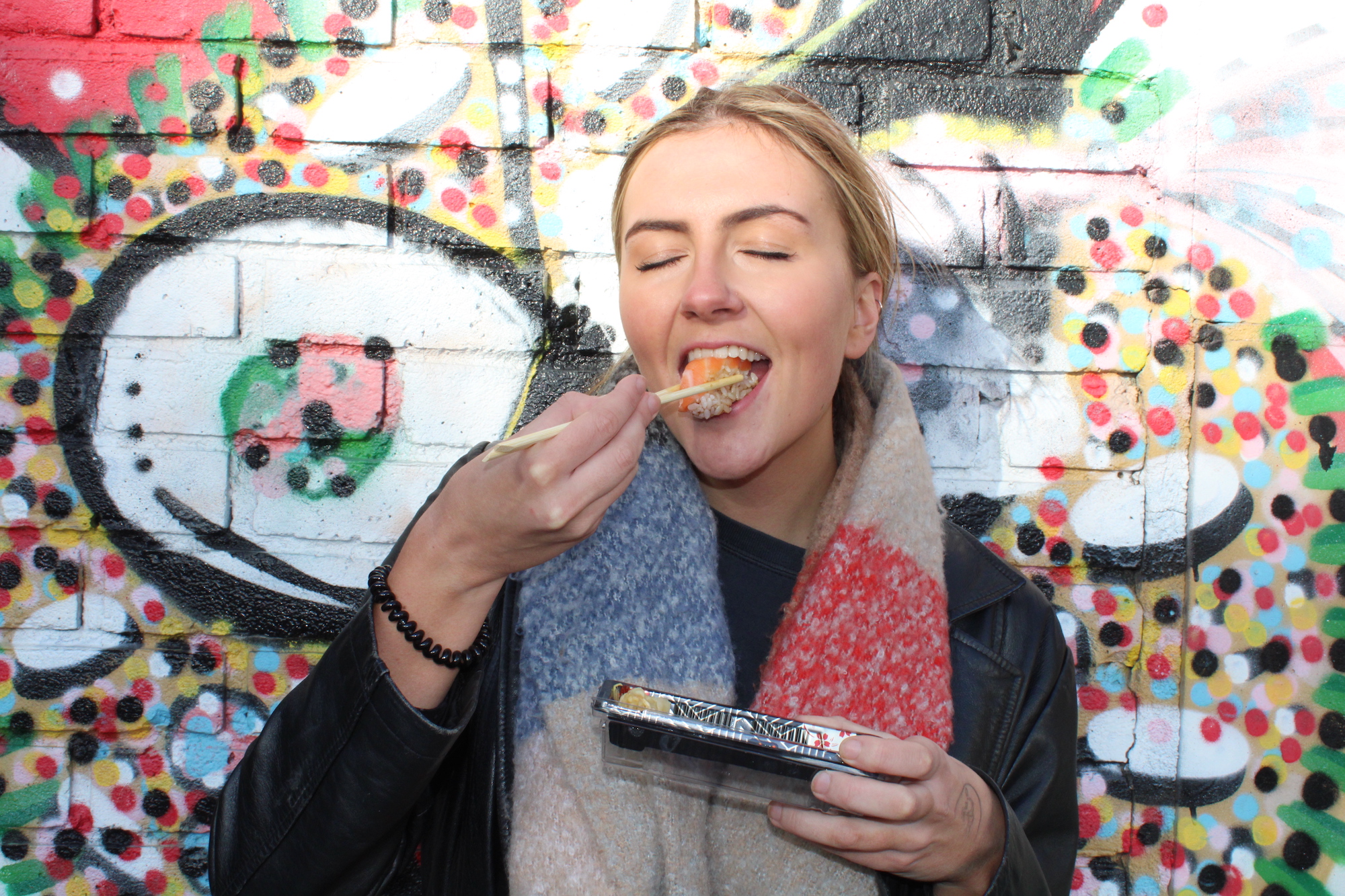 The author eating takeaway sushi outside