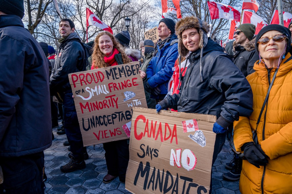 Protesters hold signs during an Anti-Vaccine Mandate rally in Queens Park, Toronto, in solidarity with the "Freedom Convoy." (Shawn Goldberg/SOPA Images/LightRocket via Getty Images)​