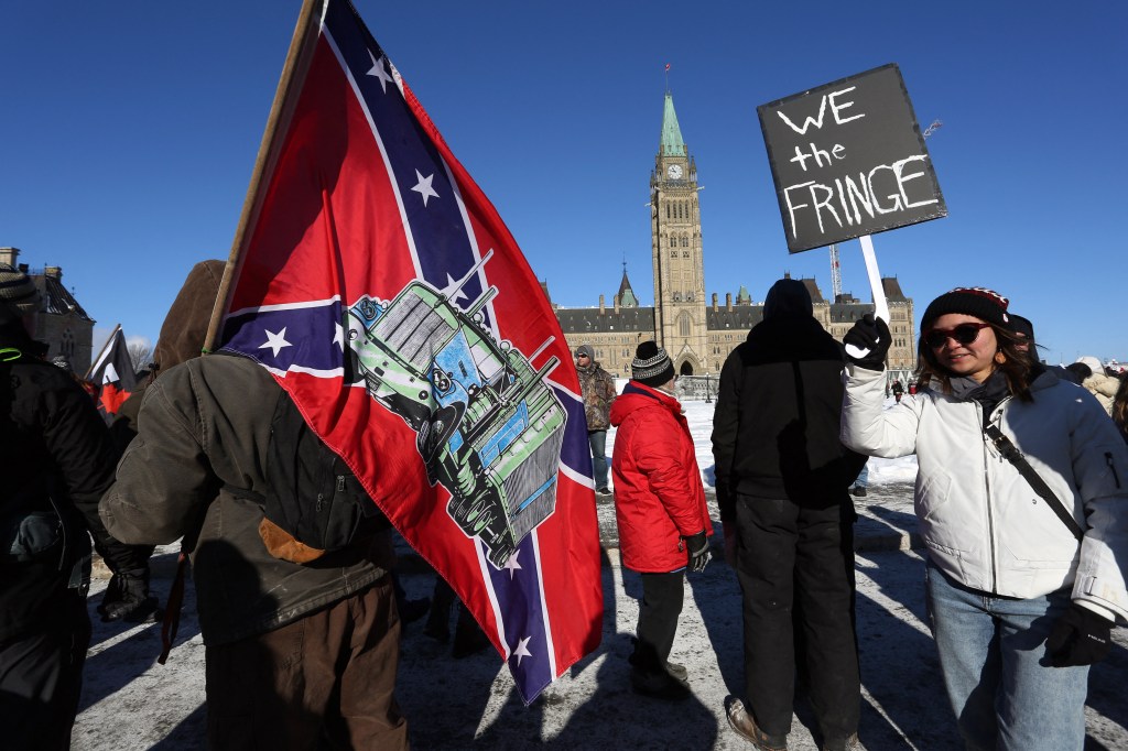 A supporter carries a US Confederate flag during the Freedom Convoy protesting Covid-19 vaccine mandates and restrictions in front of Parliament on January 29, 2022 in Ottawa, Canada.