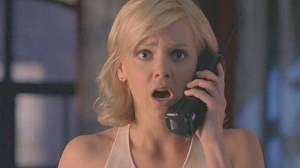 Anna Faris holds a phone looking shocked