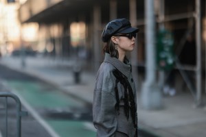 A person in a gray coat is photographed on the street during NYC Fashion Week 2022