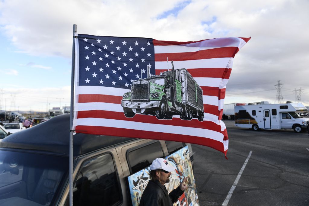 People gather to rally with truckers at the start of "The Peoples Convoy" protest against Covid-19 vaccine and mask mandates in Adelanto, California, on February 23, 2022. - The convoy is headed for Washington, DC, and is expected to arrive on March 5.