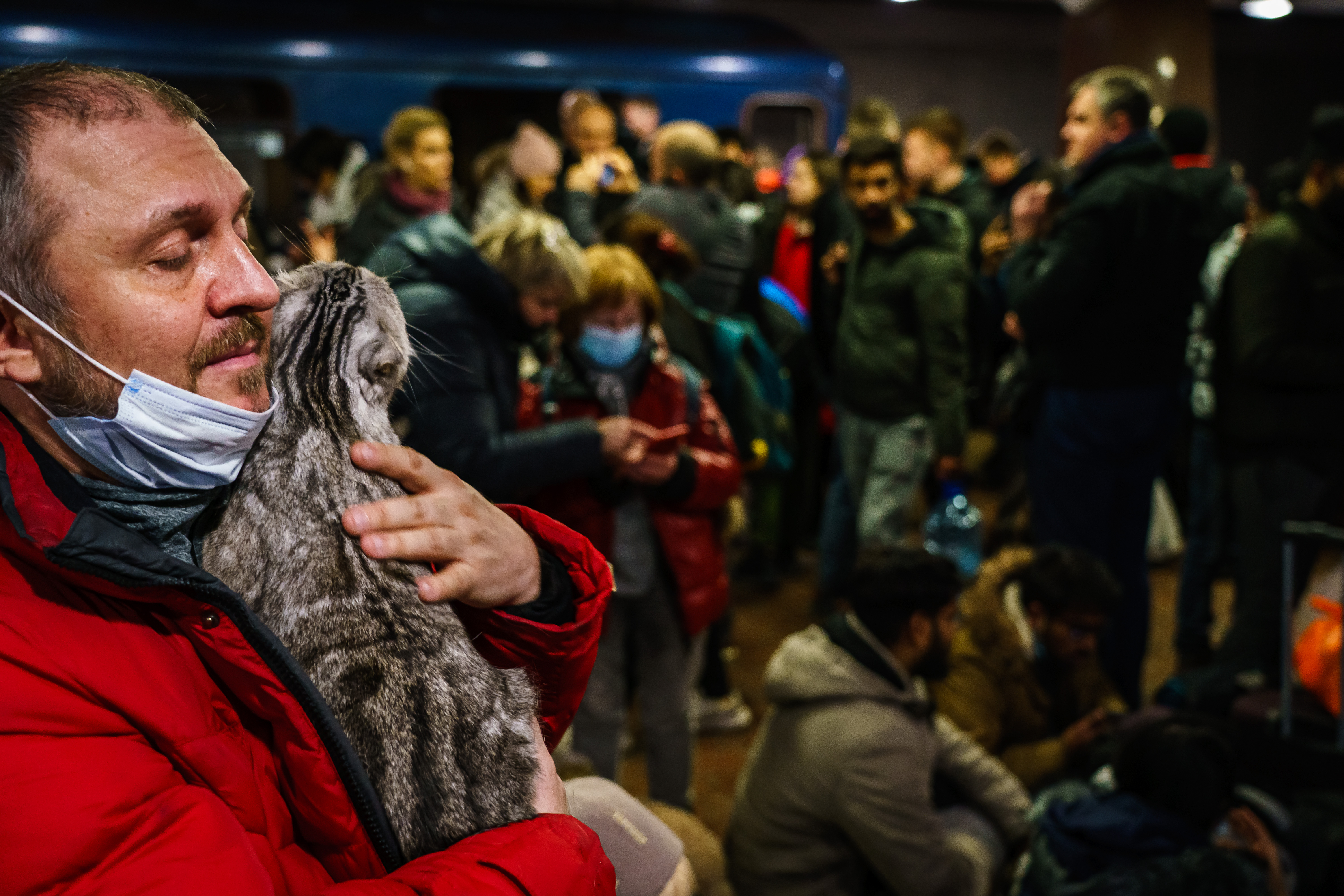 Caman Denysenko tries to calm his spooked cat as he joins hundreds of people seeking shelter underground in Kharkiv, Ukraine, Thursday, Feb. 24, 2022.