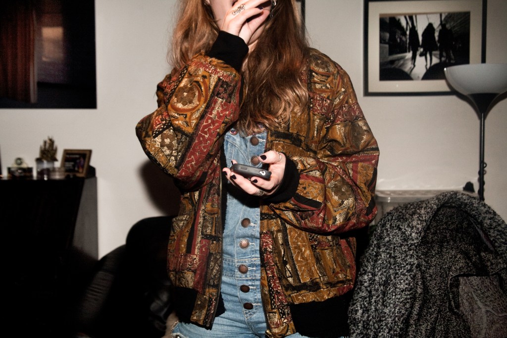 A young person checking their phone. Photo by Chris Bethell.