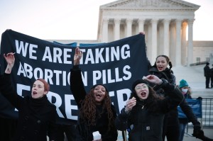 Activists take abortion pills while demonstrating in front of the U.S. Supreme Court as the justices hear hear arguments in Dobbs v. Jackson Women's Health, a case about a Mississippi law that bans most abortions after 15 weeks, on December 01, 2021 in Wa