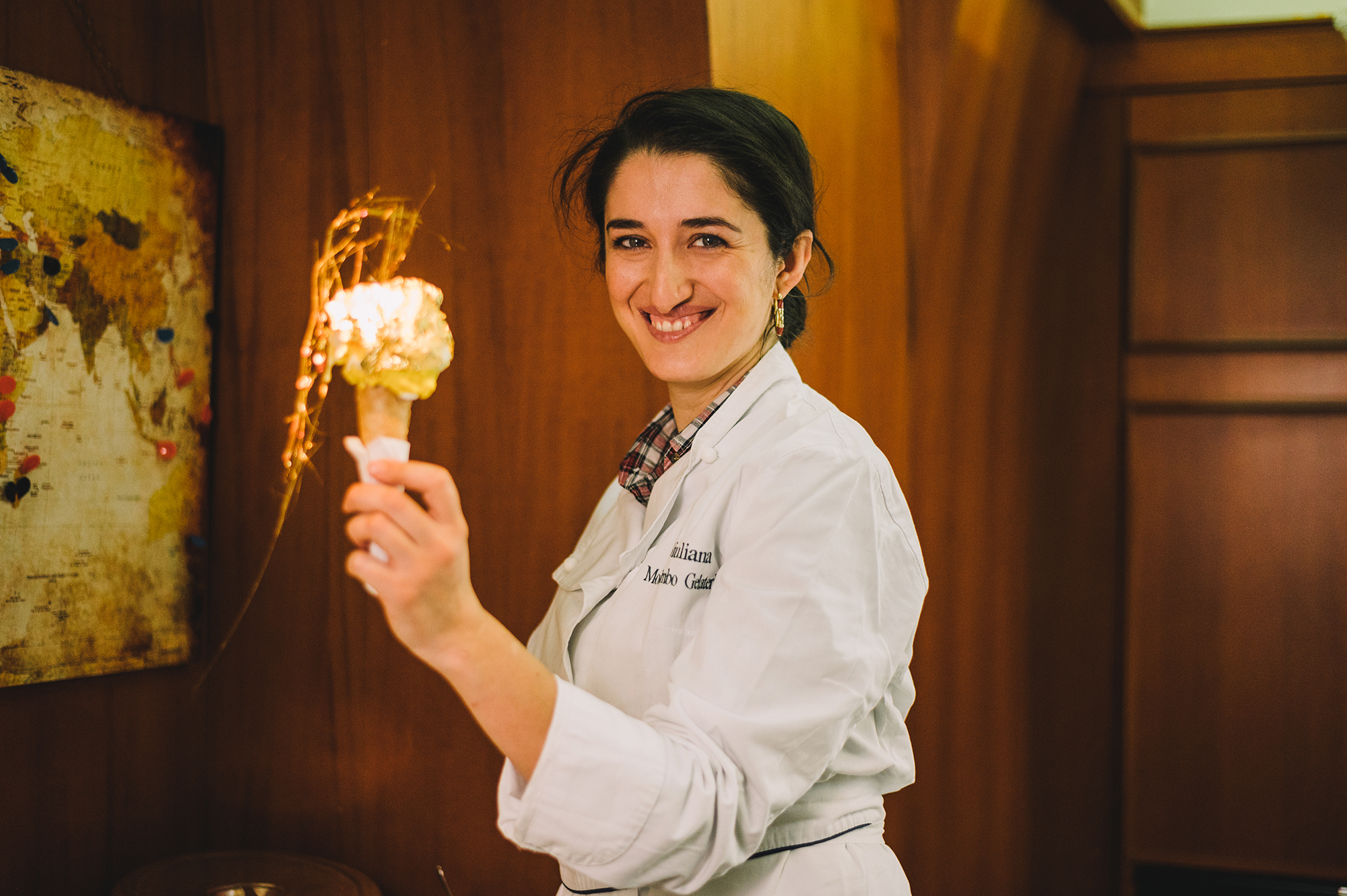 Mokambo, ice cream, Italy - Photograph of a woman in chef's whites holding up an ice cream cone.