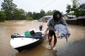 Lelaki turun dari kapal setelah mengarungi banjir