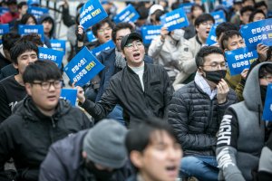 Men; rally; protest; signs; Seoul