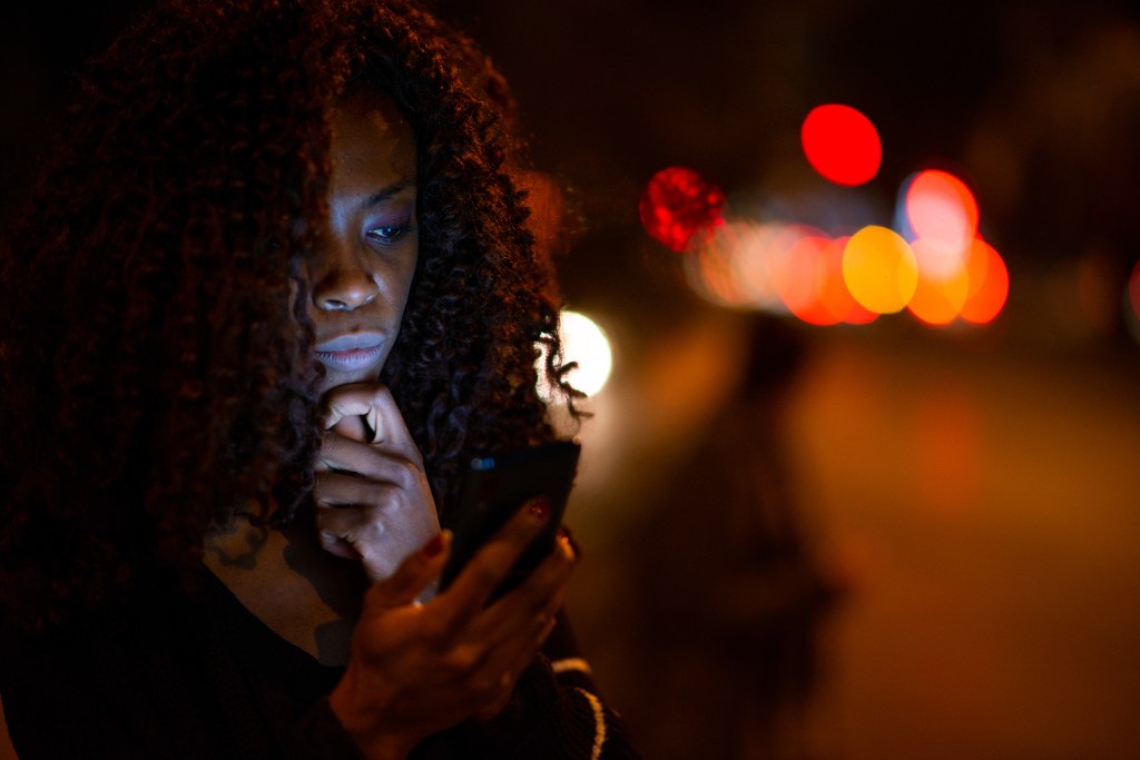 A woman looking at her phone while outside