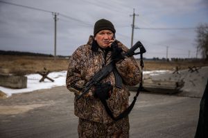 A member of Ukrainian territorial defense units talks on a phone during observation of Russian troops movements around the village of Velyka Dymerka, 40km east of Kyiv on March 9, 2022. (DIMITAR DILKOFF/AFP via Getty Images)