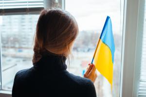 A young Russian woman holding a Ukraine flag