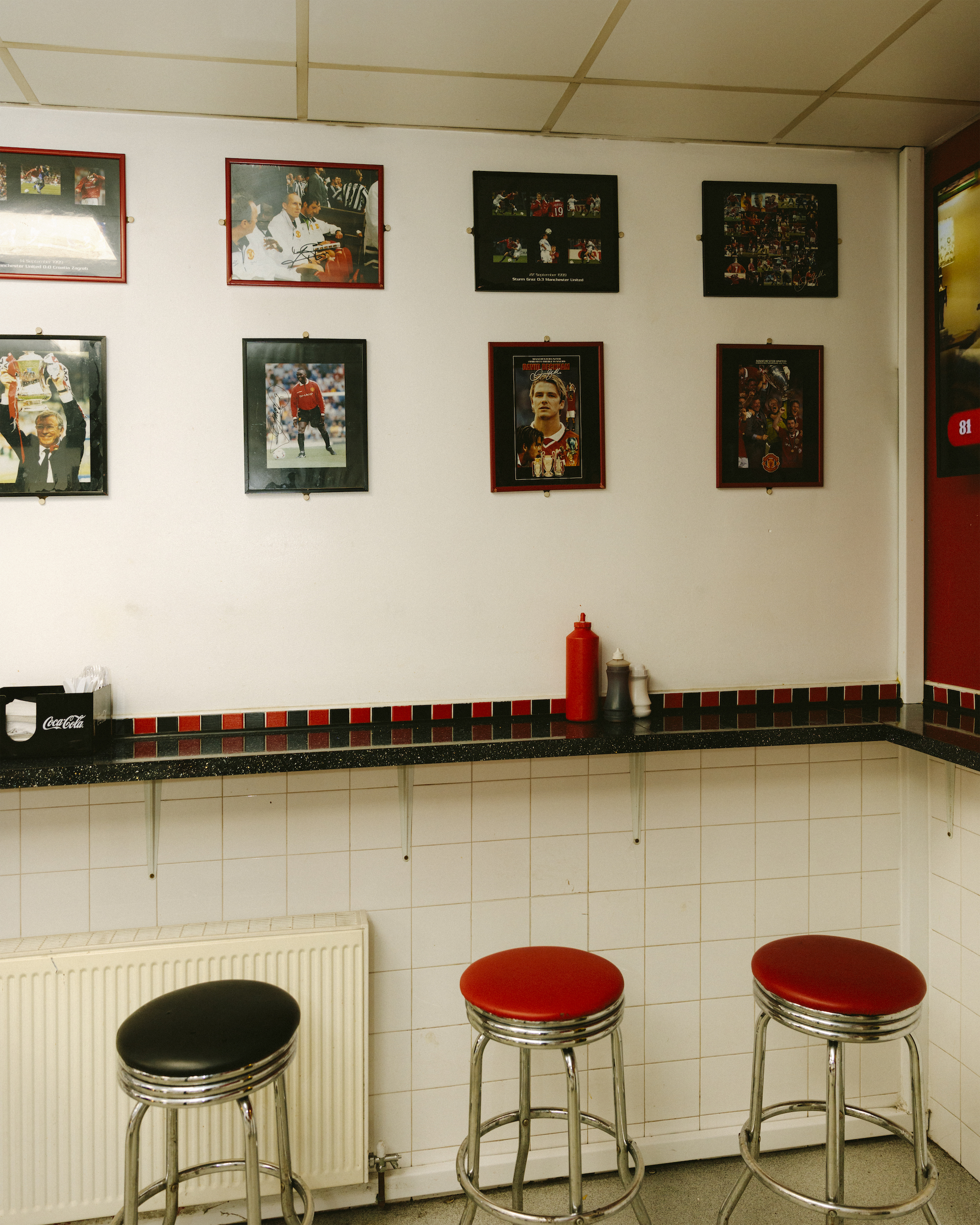 Signed photographs of Manchester United footballers on the wall of the United Cafe