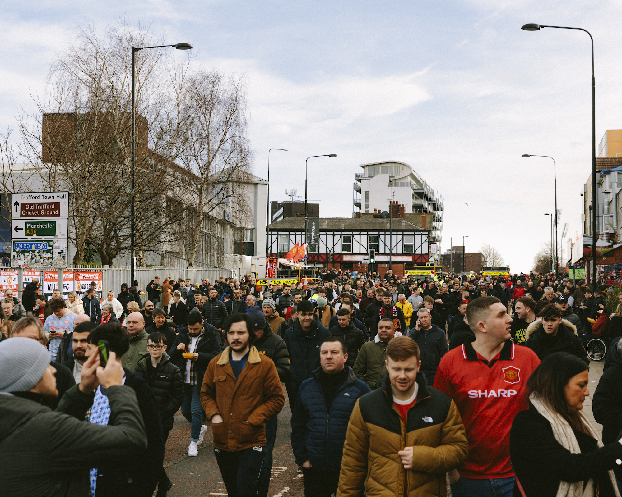 Manchester United crowd streams down Sir Matt Busby Way towards Old Trafford