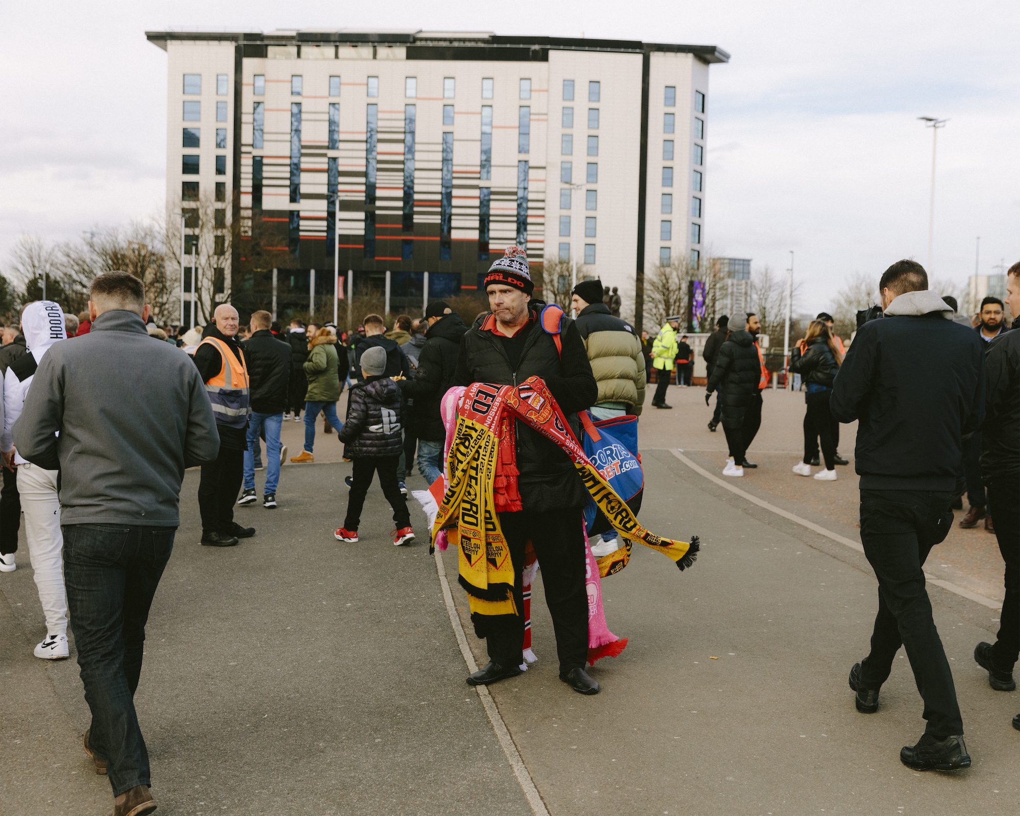 A vendor sells match scarves outside the Manchester United ground