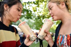 Two Asian girls drinking bubble tea in the park