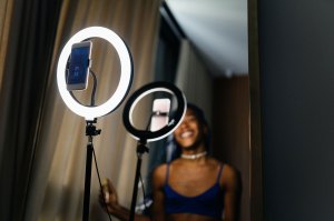 A content creator sits in front of a ring light.