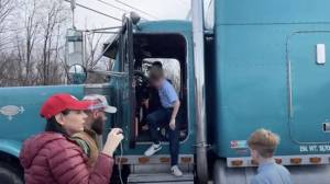 A child climbs out of one of the people's convoy trucks during some of the truckers stop at a nearby school.