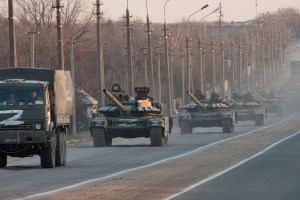 A column of tanks marked with the Z symbol stretches into the distance as they proceed northwards along the Mariupol-Donetsk highway.