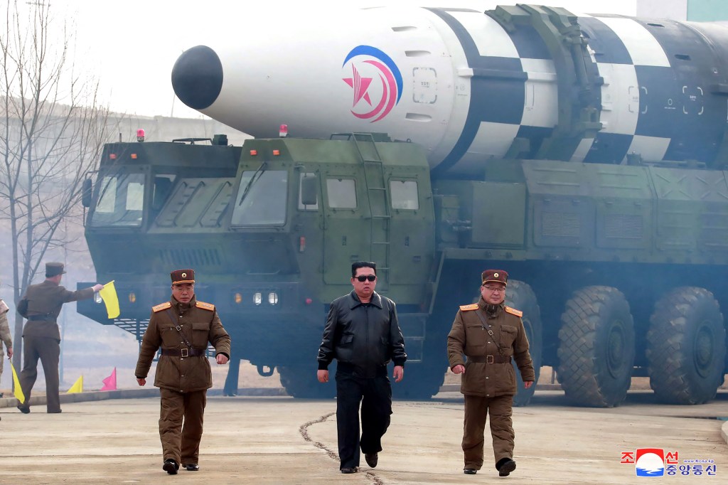 Pemimpin tertinggi Korea Utara Kim Jong-un berjalan di depan rudal balistik antarbenua Hwasong-17. Foto: AFP Photo/KCNA via KNS