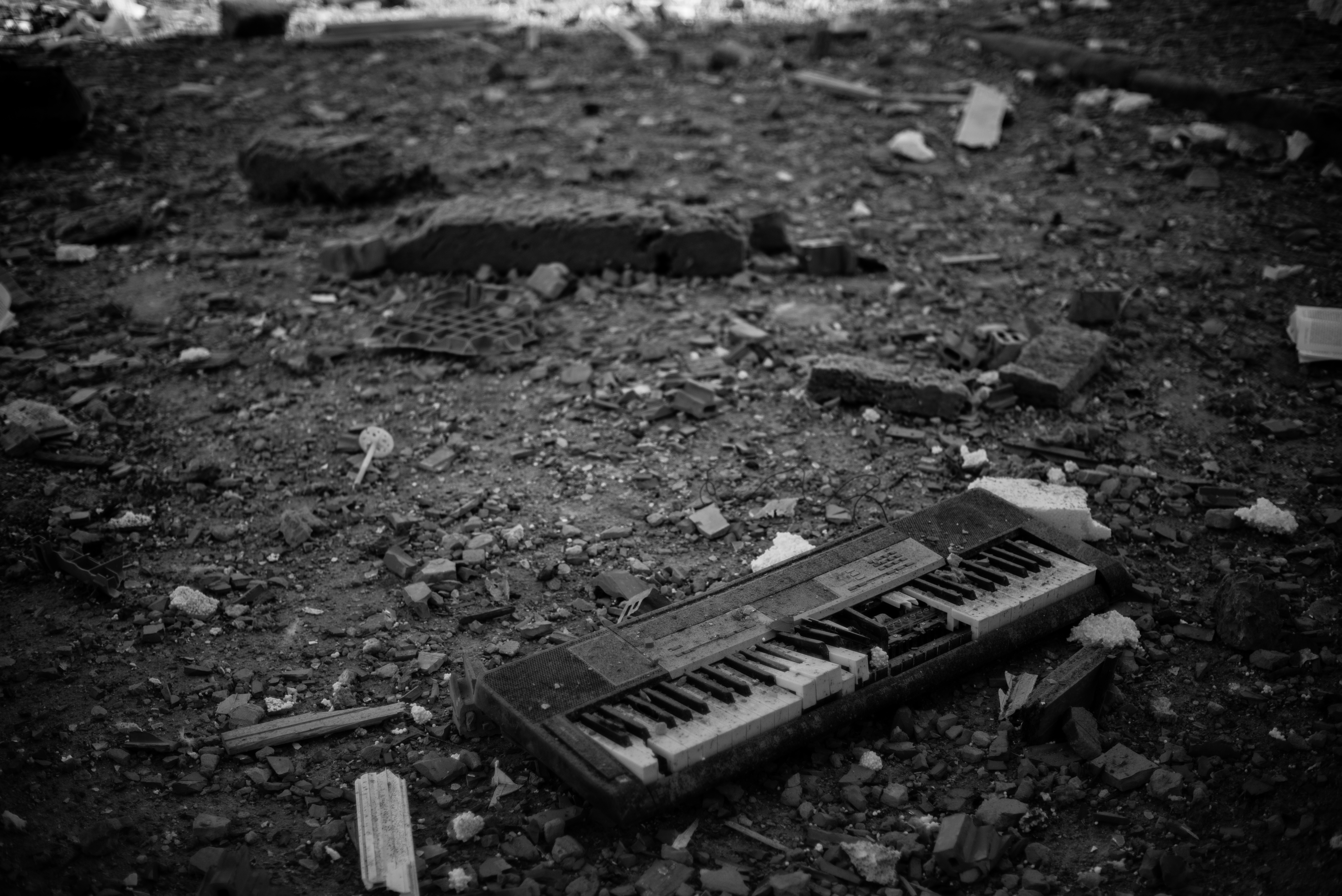 A keyboard lies on the ground near to a damaged residential building hit by a rocket attack in Kyiv in February.