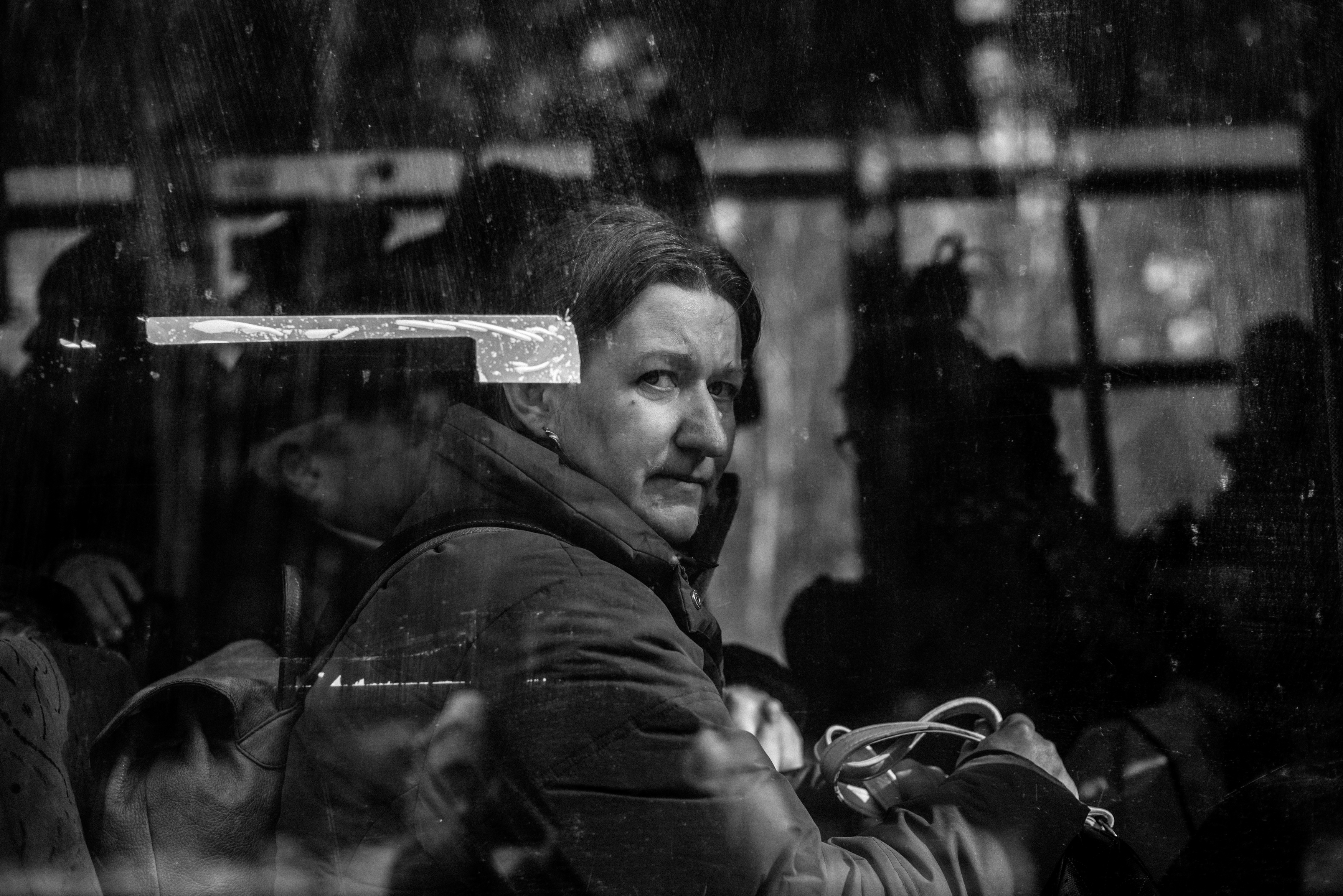 A woman sits on a bus waiting to be evacuated.